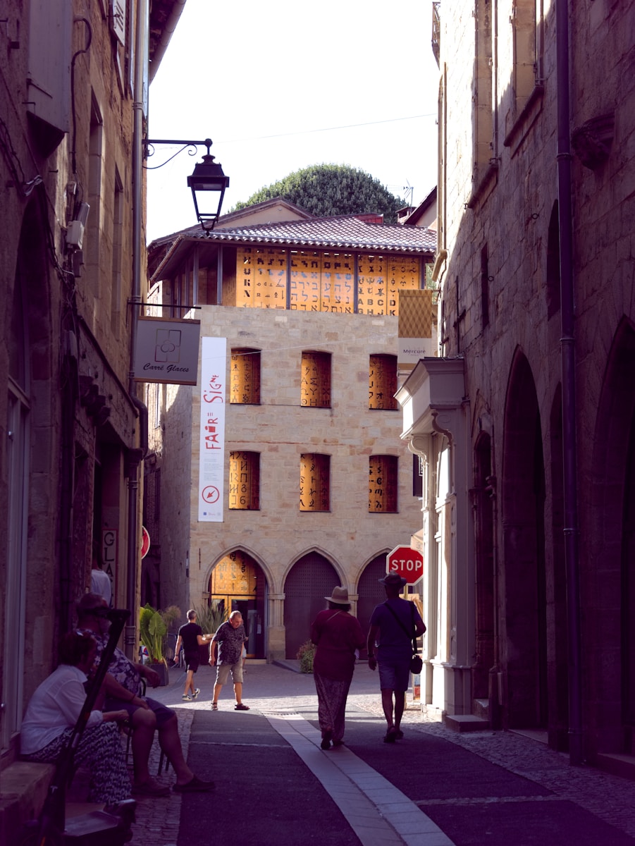 A group of people walking down a street next to tall buildings